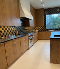 a kitchen with wooden cabinets and black and yellow checkered tile