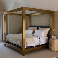 a gold canopy bed in a bedroom