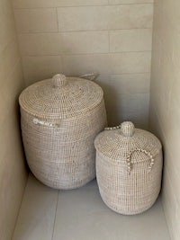 two rattan baskets sitting on a tiled floor