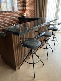 a bar with stools and a brick wall