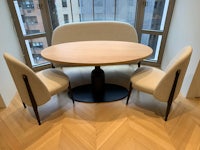 a dining table and chairs in front of a window