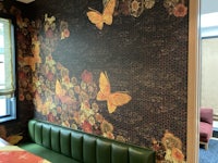 a room with a green sofa and butterflies on the wall